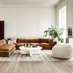 a living room filled with furniture and a large white coffee table in front of a window