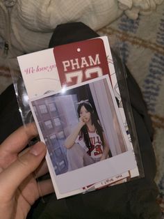 a person holding up a card with the name pham 52 on it in front of their face