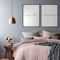 two black and white floral prints on the wall above a bed in a bedroom with pink linens