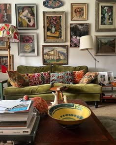 a living room filled with furniture and lots of pictures on the wall above it's coffee table