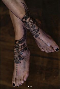 a woman's feet with tattoos on them