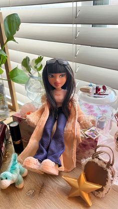 a doll sitting on top of a wooden table next to a star and other items