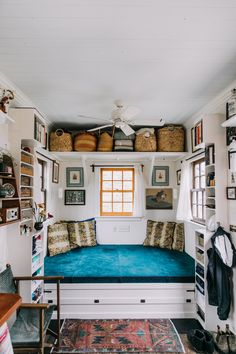 a blue couch sitting under a window in a room