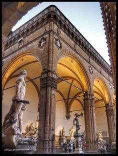 the inside of a building with statues and arches on it's sides, in front of an archway