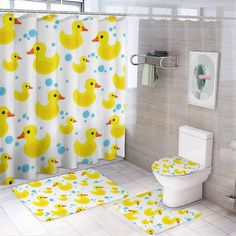 a bathroom with yellow rubber ducks on the shower curtain and rugs for the floor