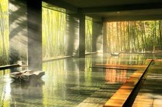 the inside of a building with water and bamboo trees in the backgrouds