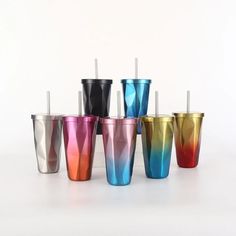 six different colored tumblers with straws in them on a white surface, all lined up against one another