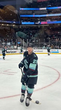 a hockey player standing on the ice in front of an empty arena during a game