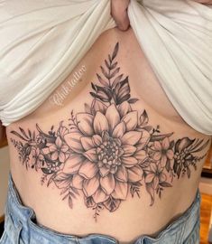 a woman's stomach with flowers and leaves on it