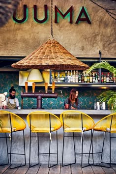 people sitting at a bar with yellow chairs