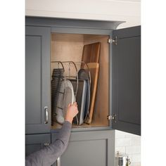 a person is opening the cabinet with their shoes and pans in it to look at them