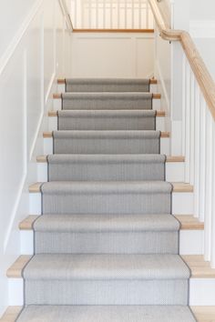 a set of stairs leading up to a second floor with carpet on the bottom and handrails