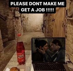 a laptop computer sitting on top of a table next to a bottle of soda and donut