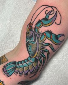 a colorful crab tattoo on the left arm