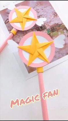 two pink and yellow paper stars on top of each other with the words magic fan above them