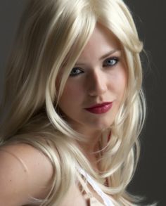 a woman with long blonde hair is posing for the camera and looking at the camera