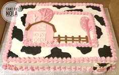 a cake that is decorated with pink and black decorations on top of a sheet covered in icing