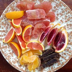 a plate with blood oranges and other fruits on it