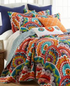 an orange and blue comforter set on a bed