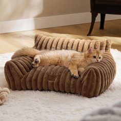 an orange cat laying on top of a couch in the middle of a living room