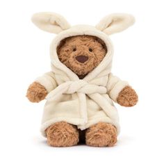 a brown teddy bear wearing a white robe and bunny ears on it's head