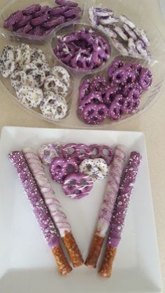 purple and white donuts are arranged in the shape of a triangle on a plate