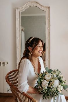 a woman sitting in a chair holding a bouquet