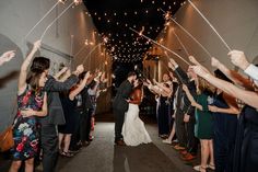 a bride and groom walk down the aisle with sparklers in their hands