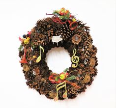 a christmas wreath with musical notes and pine cones