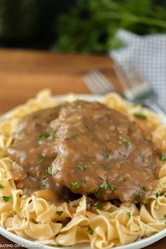 a white plate topped with pasta covered in gravy