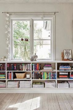 there are two pictures of the same room with bookshelves and windows in it