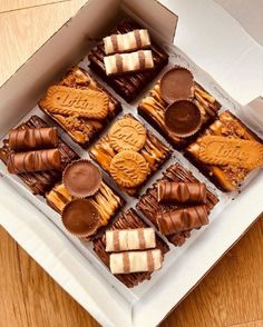 a box filled with assorted chocolates on top of a wooden table