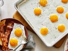 eggs and bacon on a plate next to a baking pan with an egg in it