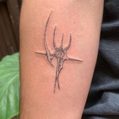 a tattoo on the arm of a man with a horned head and crossbones