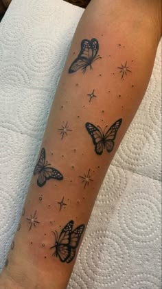 a woman's arm with butterflies and stars tattoo on the left side of her leg