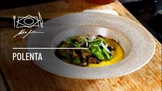 a white bowl filled with food on top of a wooden table