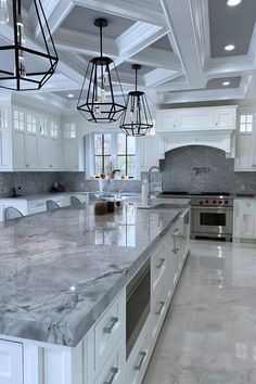 a large kitchen with marble counter tops and white cabinets