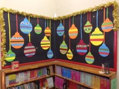 a library with christmas ornaments hanging from the ceiling and bookshelves filled with children's books