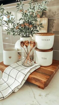 kitchen utensils are sitting on a cutting board next to a potted plant