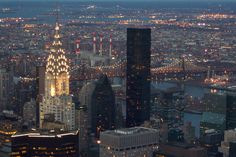 an aerial view of new york city at night with the empire building in the foreground