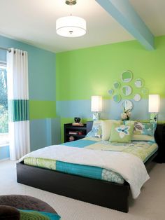 a bed room with a neatly made bed and green walls