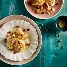 two plates filled with food sitting on top of a blue wooden table next to another plate