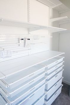 there are many shelves in the room with bins on each shelf and one is empty