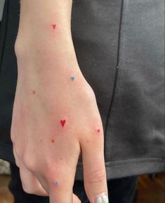 a person's hand with small red and blue dots on the thumbnails