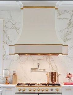 a stove top oven sitting inside of a kitchen next to a wall mounted range hood