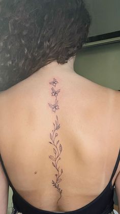 the back of a woman's neck with flowers on it