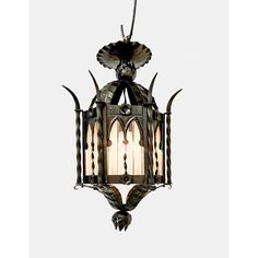 an old fashioned hanging light fixture with glass panels and metal details on the bottom part