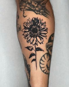 a man's leg with tattoos on it and a sunflower in the center