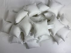 a pile of white pillows sitting on top of a table