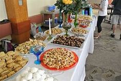 a table filled with desserts and pastries on top of white tables clothed